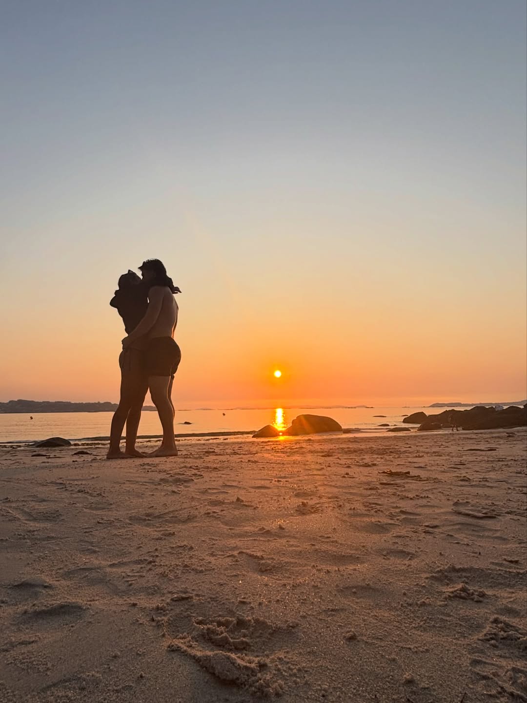 Brenda y Martín abrazados en la playa al atardecer
